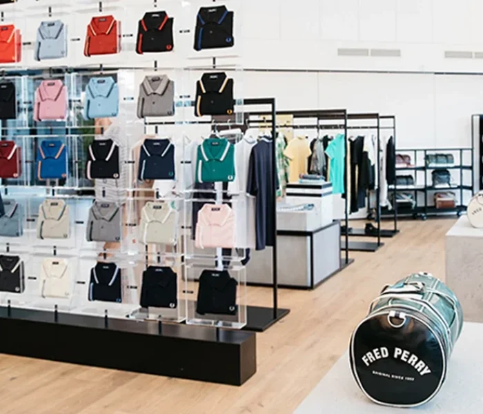 Tienda de ropa con expositores cuadrados de metacrilato transparente con ropa suspendida